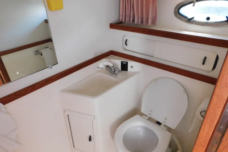 Slide: The Image of Bathroom interior of 1993 Tiara Yachts 3100 Open, featuring sink and toilet. - 83
