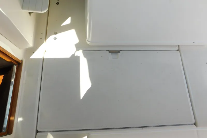 Slide: The Image of 1993 Tiara Yachts 3100 Open deck with storage hatch and sunlight shadows. - 85