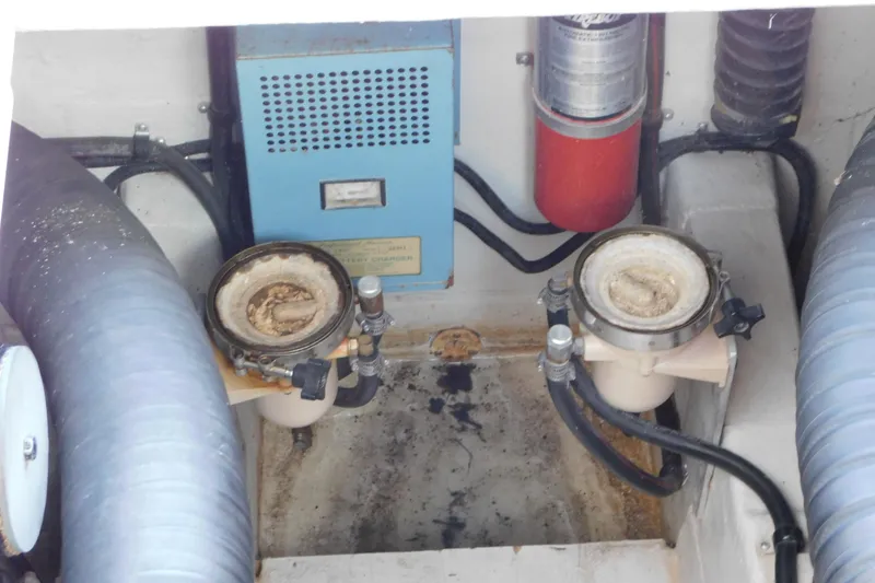 Slide: The Image of Engine compartment of a 1993 Tiara Yachts 3100 Open, featuring filters and hoses. - 90