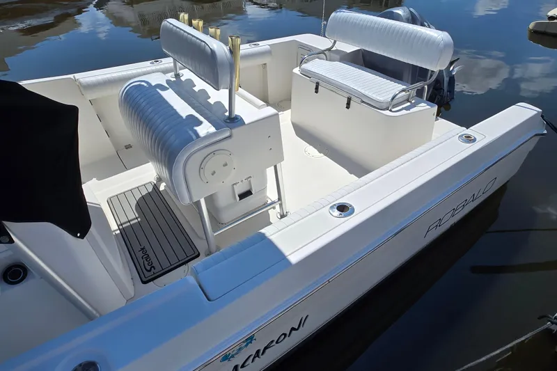 Slide: The Image of 2003 Robalo R230 Center Console boat interior with seating and rod holders. - 2