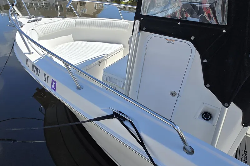 Slide: The Image of 2003 Robalo R230 Center Console boat with white seating and sleek design. - 3
