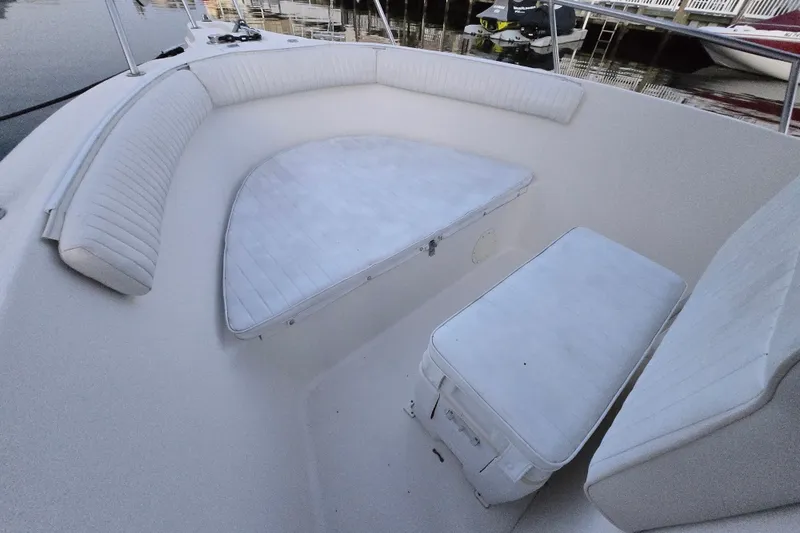 Slide: The Image of 2003 Robalo R230 Center Console boat interior with white cushioned seating. - 7