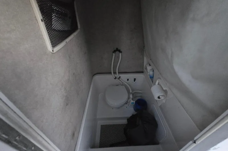 Slide: The Image of 2003 Robalo R230 Center Console boat interior with compact marine toilet setup. - 8