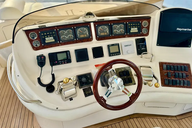Slide: The Image of 1998 Sea Ray 480 Sedan Bridge helm with gauges, controls, and Raymarine display. - 14