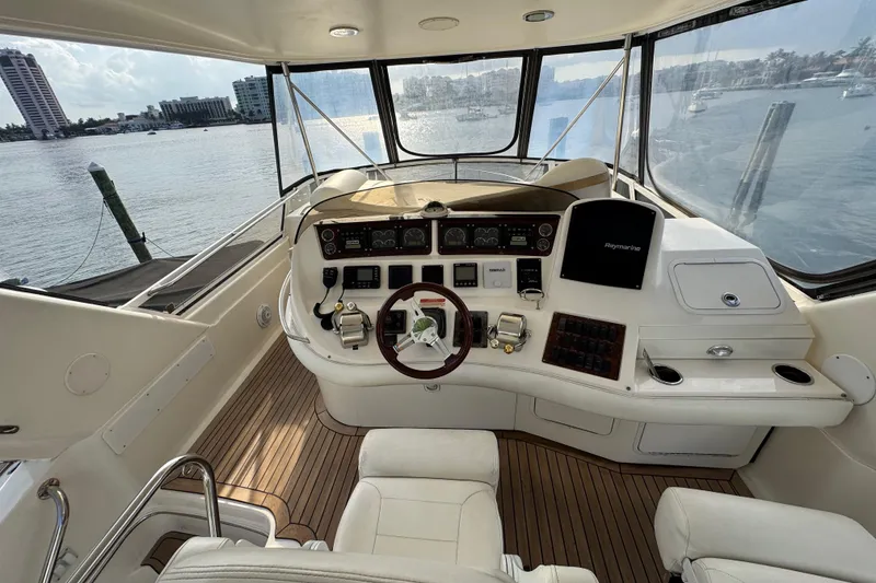 Slide: The Image of 1998 Sea Ray 480 Sedan Bridge helm with panoramic water view and modern controls. - 15