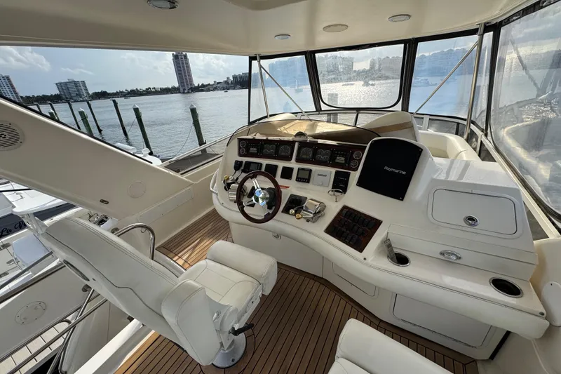 Slide: The Image of Interior view of 1998 Sea Ray 480 Sedan Bridge yacht helm with waterfront backdrop. - 16