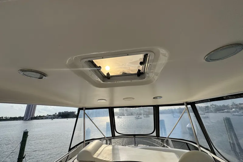 Slide: The Image of Interior view of 1998 Sea Ray 480 Sedan Bridge yacht with sunroof and waterfront backdrop. - 29