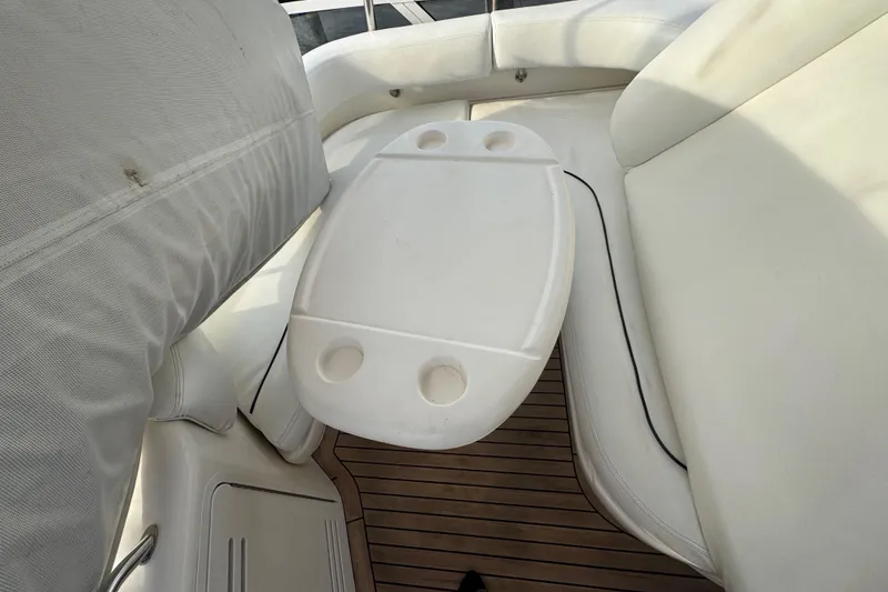 Slide: The Image of 1998 Sea Ray 480 Sedan Bridge yacht interior with seating and table, overlooking marina. - 32