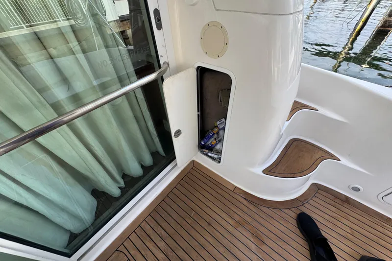 Slide: The Image of 1998 Sea Ray 480 Sedan Bridge deck with open storage compartment and teak flooring. - 39