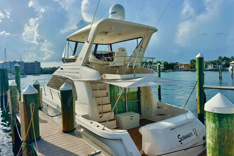 Slide: The Image of 1998 Sea Ray 480 Sedan Bridge yacht docked at marina under cloudy sky. - 4