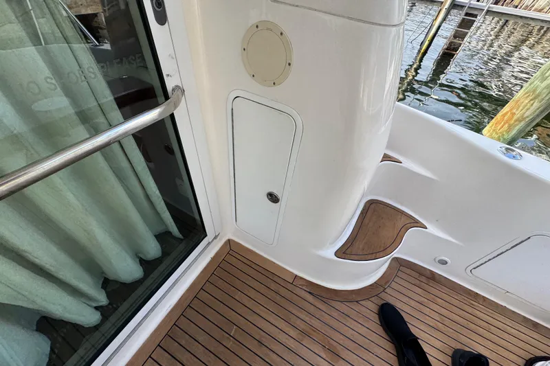 Slide: The Image of 1998 Sea Ray 480 Sedan Bridge yacht deck with wooden flooring and railing. - 40