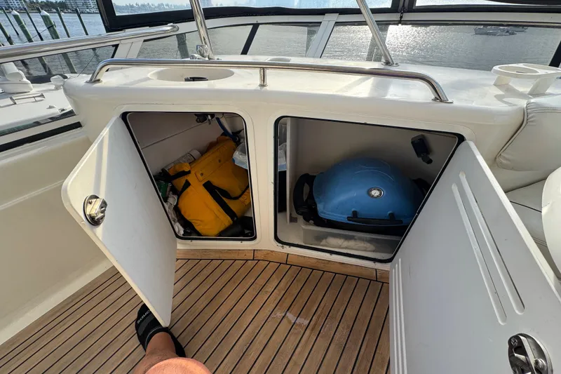 Slide: The Image of 1998 Sea Ray 480 Sedan Bridge storage compartments with safety gear and a blue grill. - 41