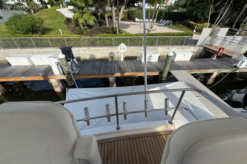 Slide: The Image of 1998 Sea Ray 480 Sedan Bridge yacht docked at a marina with lush greenery. - 45