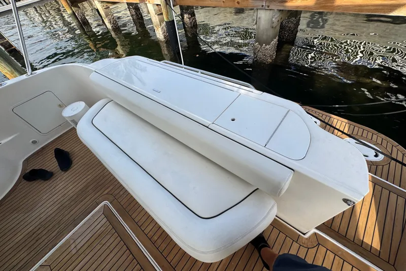 Slide: The Image of 1998 Sea Ray 480 Sedan Bridge deck with white seating and wooden flooring. - 47