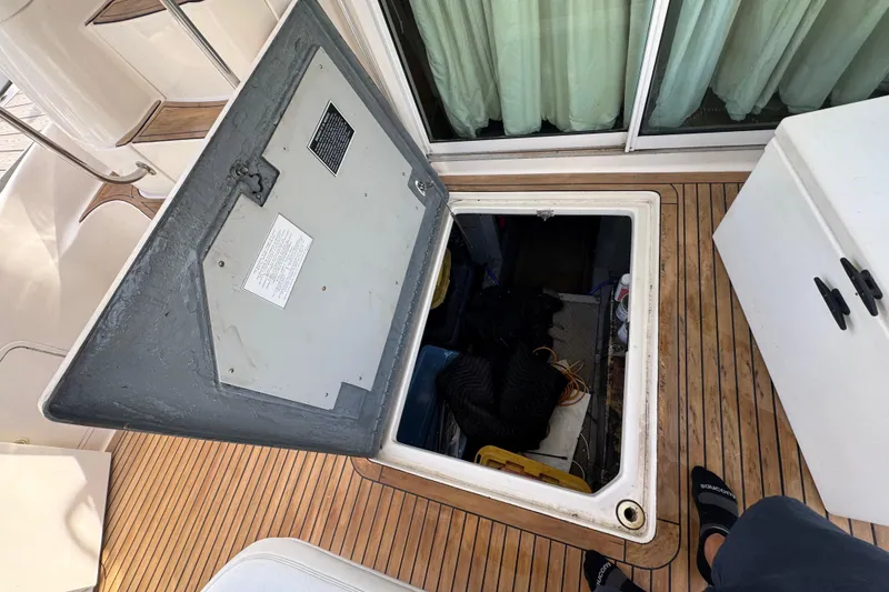 Slide: The Image of Open hatch on 1998 Sea Ray 480 Sedan Bridge boat deck, revealing storage compartment. - 50