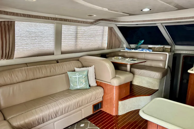 Slide: The Image of Interior of 1998 Sea Ray 480 Sedan Bridge with beige leather seating and wooden accents. - 59