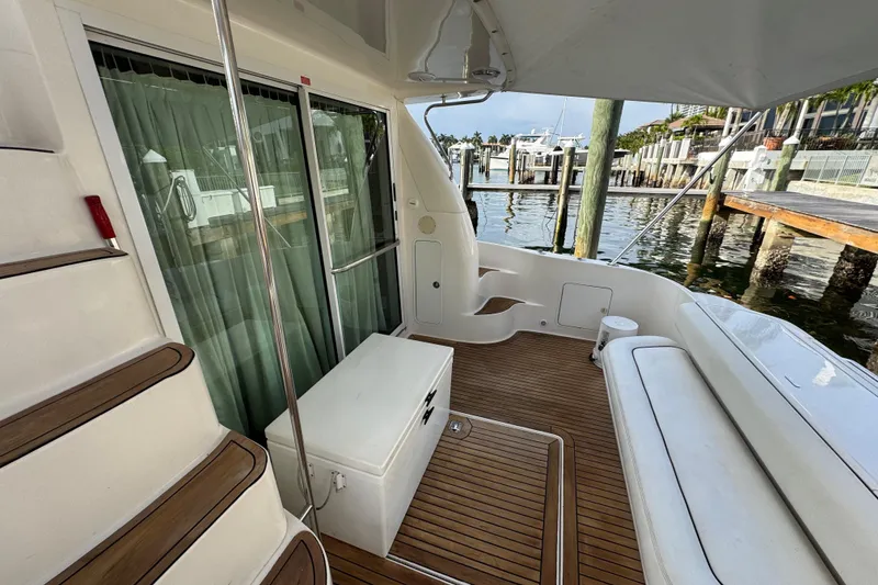 Slide: The Image of 1998 Sea Ray 480 Sedan Bridge yacht deck with wooden flooring and seating area. - 6