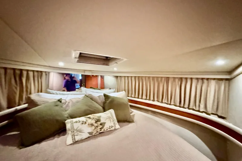 Slide: The Image of Interior cabin of 1998 Sea Ray 480 Sedan Bridge with cozy bedding and curtains. - 62