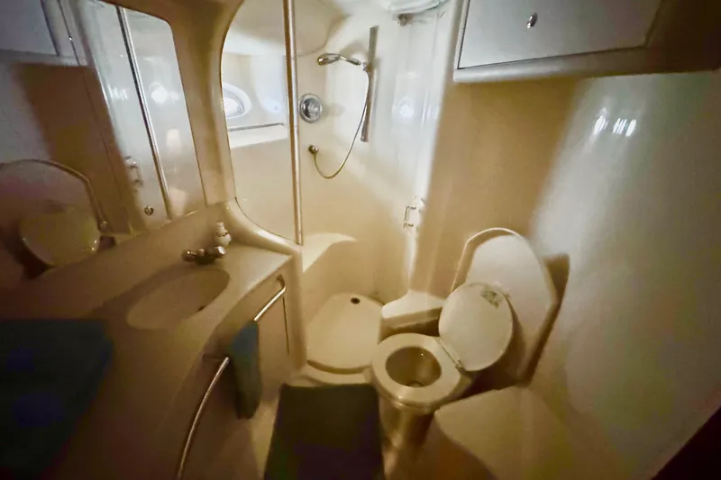 Slide: The Image of 1998 Sea Ray 480 Sedan Bridge bathroom with shower, sink, and toilet. - 64