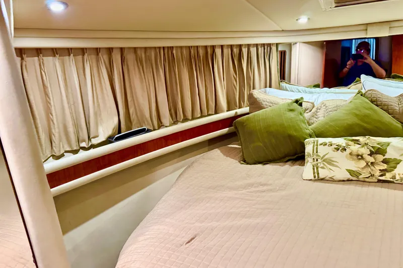 Slide: The Image of Interior cabin of 1998 Sea Ray 480 Sedan Bridge with cozy bedding and curtains. - 65