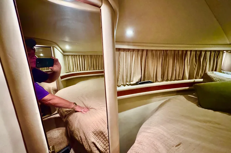 Slide: The Image of 1998 Sea Ray 480 Sedan Bridge cabin interior with cozy bedding and curtains. - 66