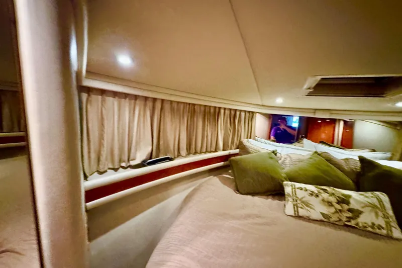 Slide: The Image of Interior cabin of 1998 Sea Ray 480 Sedan Bridge with cozy bedding and curtains. - 67