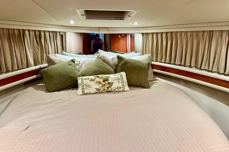 Slide: The Image of Cozy bedroom interior of 1998 Sea Ray 480 Sedan Bridge with elegant bedding and curtains. - 69