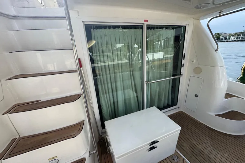 Slide: The Image of 1998 Sea Ray 480 Sedan Bridge yacht with sliding glass doors and wooden deck. - 7