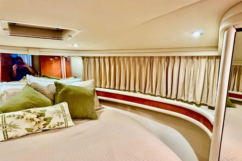 Slide: The Image of 1998 Sea Ray 480 Sedan Bridge cabin interior with cozy bedding and elegant curtains. - 70