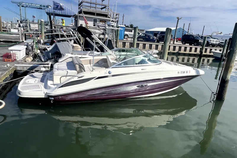 The Image of 2010 Sea Ray 220 Sundeck boat docked at marina, calm water, clear sky. - 0