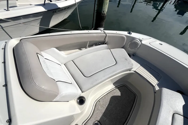 Slide: The Image of 2010 Sea Ray 220 Sundeck boat interior with cushioned seating and speaker. - 12