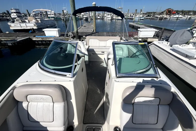 Slide: The Image of 2010 Sea Ray 220 Sundeck boat docked at marina, featuring spacious seating and sleek design. - 15