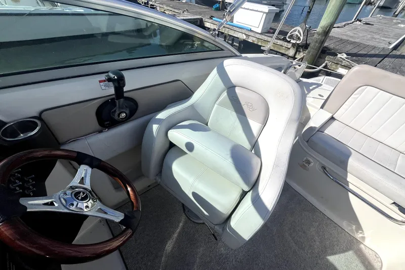 Slide: The Image of 2010 Sea Ray 220 Sundeck cockpit with steering wheel and comfortable seating. - 17