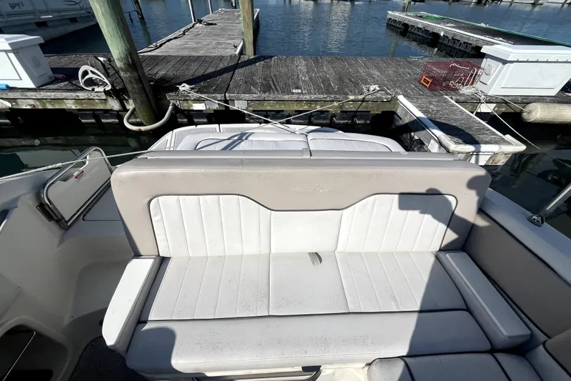 Slide: The Image of 2010 Sea Ray 220 Sundeck boat interior with white seating at a dock. - 27