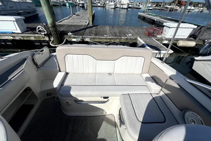 Slide: The Image of 2010 Sea Ray 220 Sundeck interior with white seating at marina dock. - 28