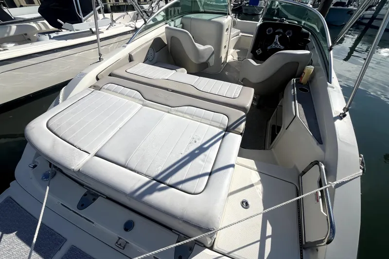 Slide: The Image of 2010 Sea Ray 220 Sundeck boat interior with white seating and steering console. - 31