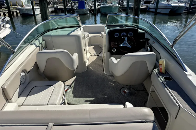 Slide: The Image of 2010 Sea Ray 220 Sundeck interior with seating and steering wheel at marina. - 32