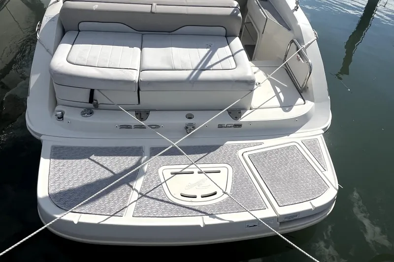 Slide: The Image of 2010 Sea Ray 220 Sundeck boat with cushioned seating and swim platform. - 33