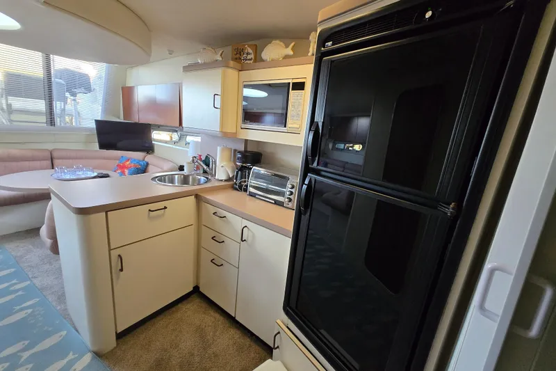 Slide: The Image of 1991 Mainship 35 Open Bridge yacht interior with kitchen and dining area. - 11