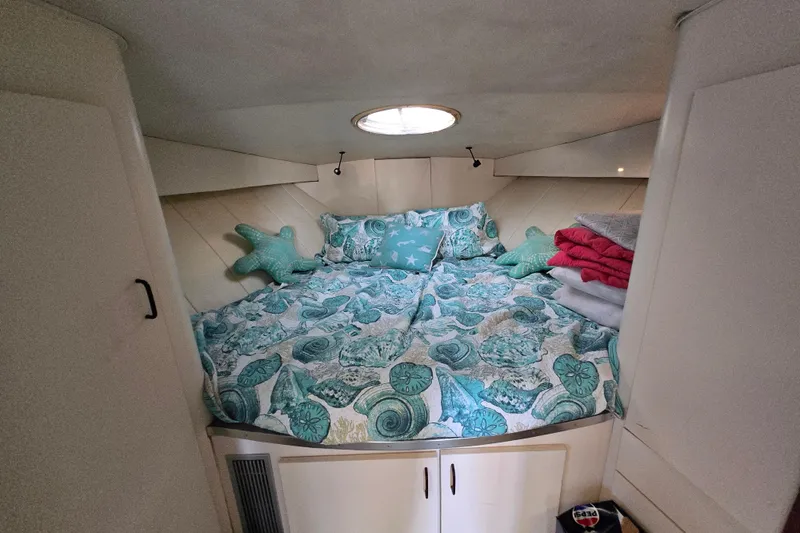 Slide: The Image of Cozy cabin interior of 1991 Mainship 35 Open Bridge with nautical-themed bedding. - 14