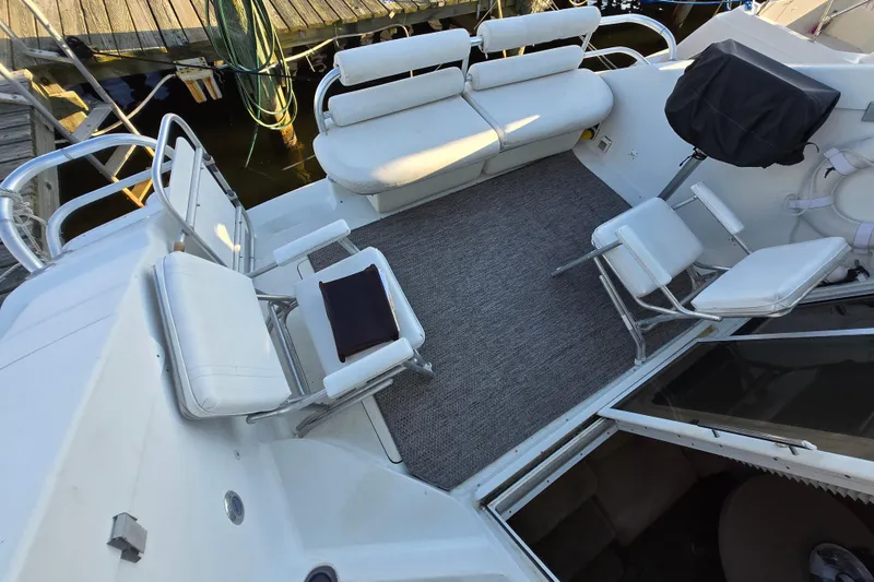 Slide: The Image of 1991 Mainship 35 Open Bridge boat deck with seating and covered grill. - 18
