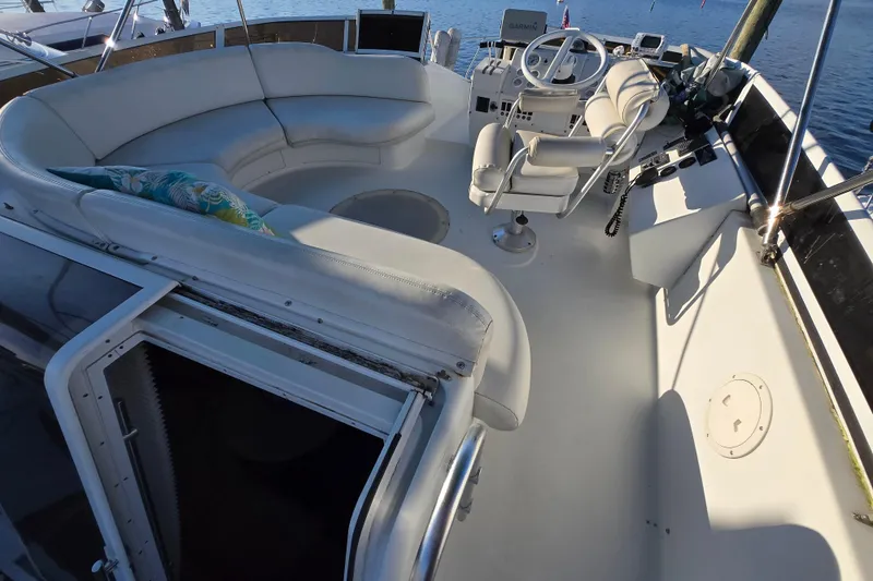 Slide: The Image of 1991 Mainship 35 Open Bridge yacht with spacious seating and helm, docked by the water. - 20