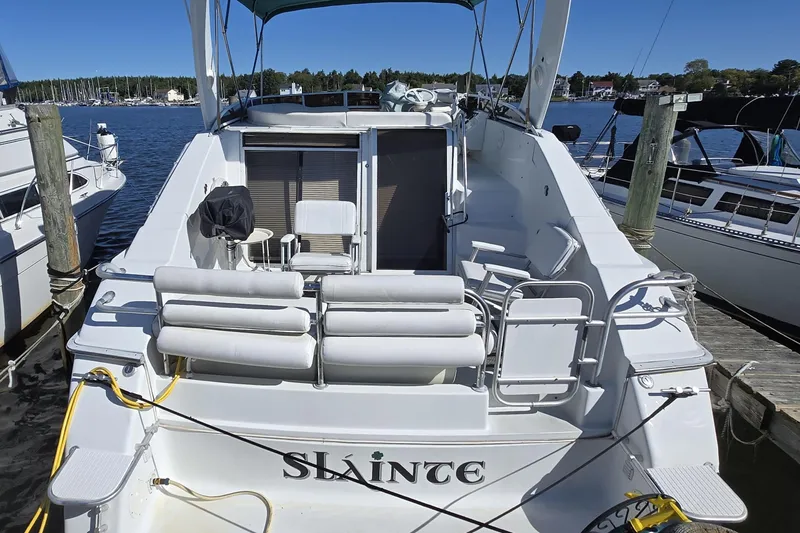 Slide: The Image of 1991 Mainship 35 Open Bridge yacht docked, featuring spacious seating and open deck design. - 3