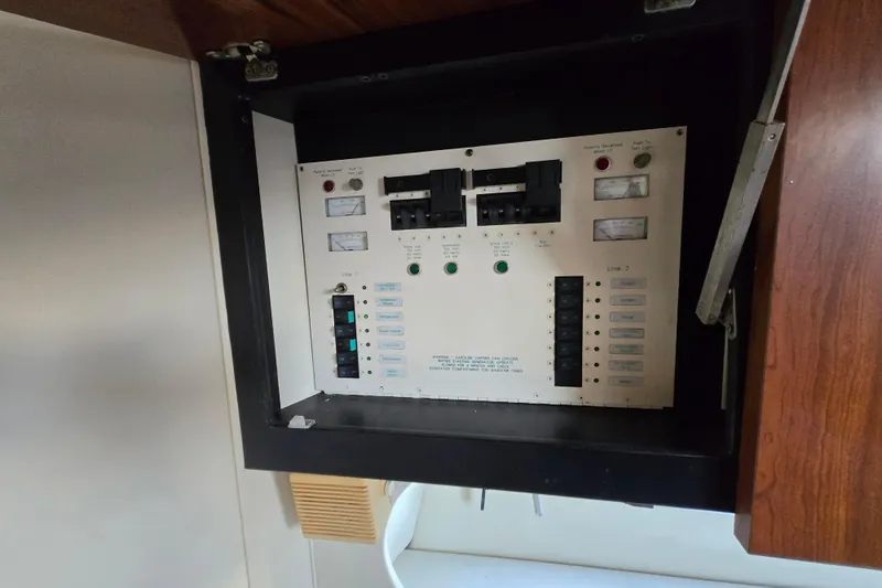 Slide: The Image of Electrical panel inside 1991 Mainship 35 Open Bridge boat, featuring switches and meters. - 31