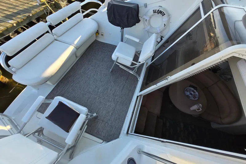 Slide: The Image of 1991 Mainship 35 Open Bridge yacht deck with seating and interior view. - 8