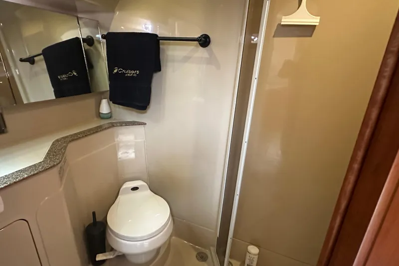 Slide: The Image of 2001 Cruisers Yachts 3870 Express bathroom with toilet, towel, and shower area. - 11