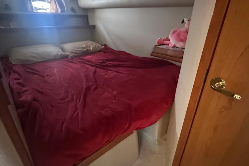 Slide: The Image of Cozy bedroom in 2001 Cruisers Yachts 3870 Express with red bedding and plush decor. - 13