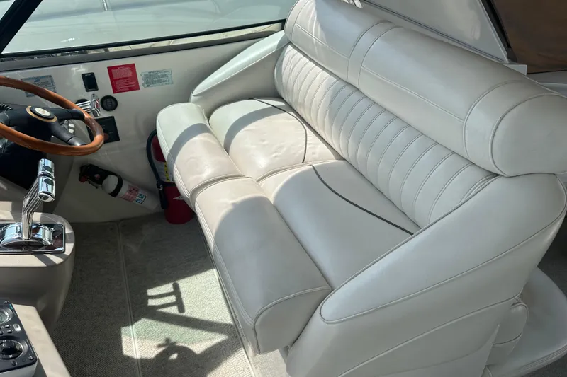 Slide: The Image of 2001 Cruisers Yachts 3870 Express cockpit with white leather seating and wooden steering wheel. - 5