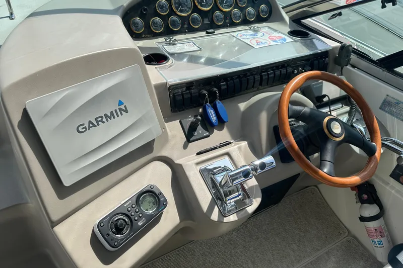 Slide: The Image of 2001 Cruisers Yachts 3870 Express helm with Garmin navigation and wooden steering wheel. - 7