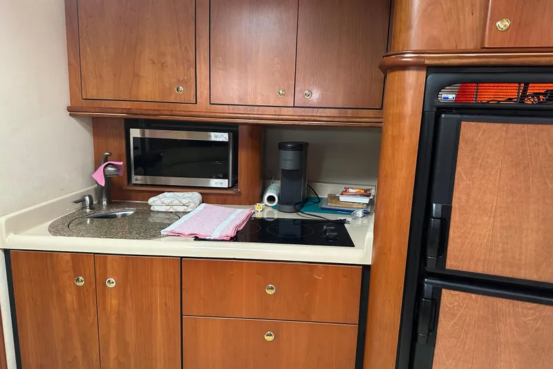 Slide: The Image of 2001 Cruisers Yachts 3870 Express kitchen with wood cabinets, sink, and appliances. - 8